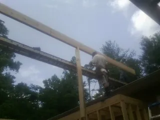 Carpenter setting a ridge beam over a new addition frame — Ice Dam Removal by Roofing Brothers in Stevensville