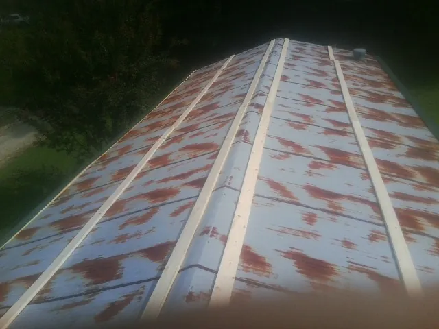 Rusted metal roof panels with new wood purlins before replacement — Storm Damage Roof Repair in Stevensville by Roofing Brothers